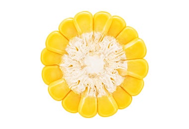 Granos de maíz amarillos organizados para que parezcan una flor.