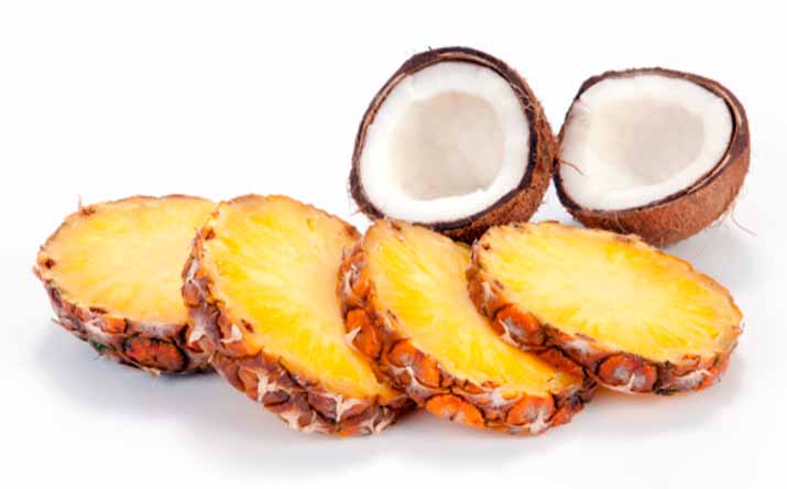 Tajadas de piña y un coco partido por la mitad, dos frutas tropicales. Tajadas de piña y un coco partido por la mitad, dos frutas tropicales.