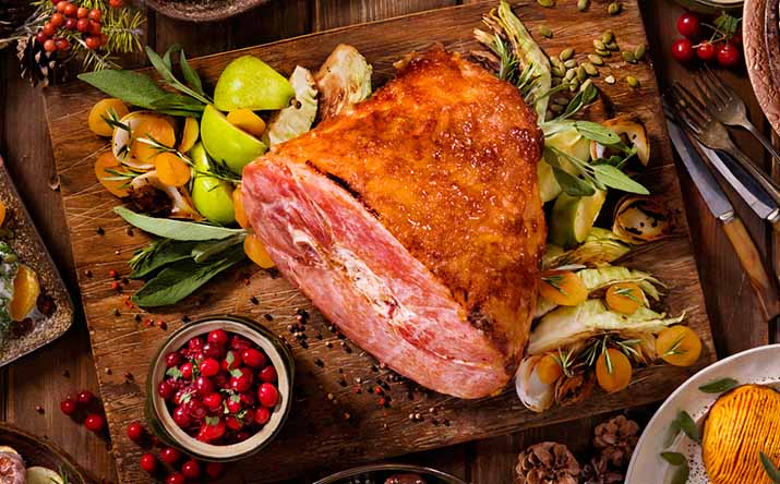 Un jamón de pavo acompañado de diferentes guarniciones navideñas. Un jamón de pavo acompañado de diferentes guarniciones navideñas.