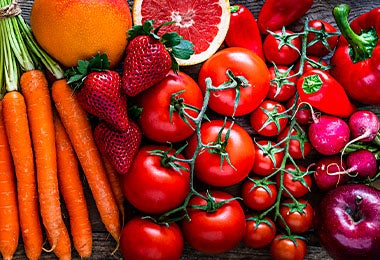 Tomates junto a otras frutas y verduras, como zanahorias y frutillas.