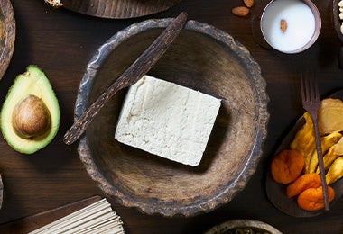 Tofu, una carne vegetal, en un plato de madera. Tofu, una carne vegetal, en un plato de madera.