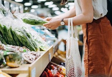 Mujer eligiendo hortalizas en supermercado clasificación alimentos Mujer eligiendo hortalizas en supermercado clasificación alimentos