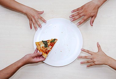 Plato con pizza y manos para calcular porciones de alimentos Plato con pizza y manos para calcular porciones de alimentos