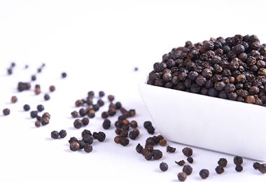 Recipiente con granos enteros de pimienta negra Recipiente con granos enteros de pimienta negra