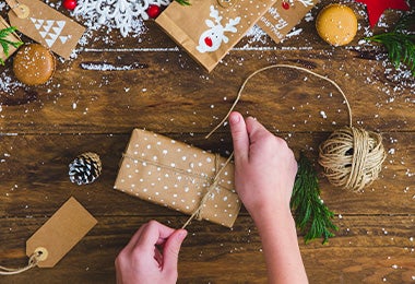 La Navidad es una época llena de regalos. Una persona envolviendo un regalo de Navidad.