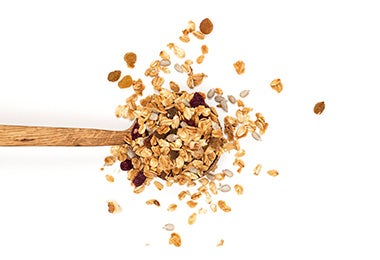Cuchara con mezcla de ingredientes para hacer granola Cuchara con mezcla de ingredientes para hacer granola