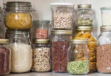 Frascos con alimentos secos, entre ellos ají cacho de cabra, en una despensa organizada