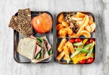 Lonchera con sandwich, semillas y frutas para alimentación escolar completa