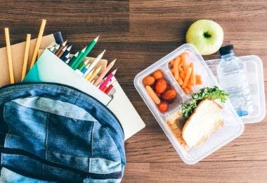 Lonchera escolar con sándwich, zanahorias y agua para alimentación equilibrada