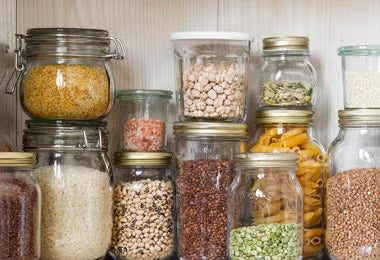 Frascos de bulgur y otros granos almacenados en una despensa organizada