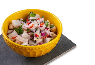 Tazón de ceviche con cebolla cortado en julianas irregulares.