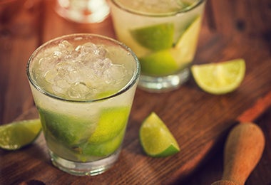 Dos vasos de coctel de limón con hielo.