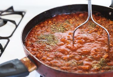 Porotos en una sartén, sazonados con hierbas aromáticas y sal. 