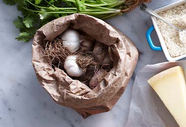 Ajos frescos guardados en una bolsa, al lado de otros ingredientes
