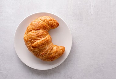 Croissant de la repostería francesa en un plato con un fondo blanco