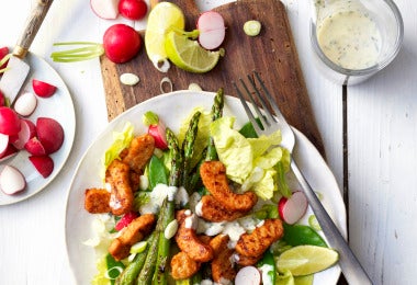 Ensalada de frutas con lechuga, duraznos asados, espárragos, rábanos y aderezo cremoso