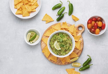 Bowl de guacamole con totopos, tomatillos, chile y limón para comer con anchoas.