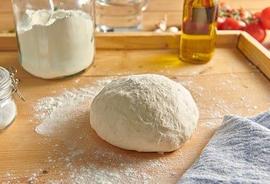 Masa de empanadillas de arroz sobre mesón de madera.