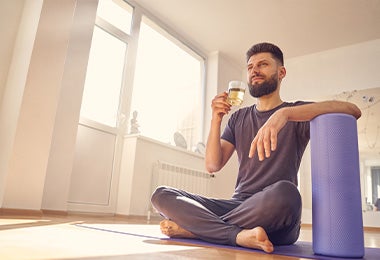 Hombre después de practicar yoga en casa con un té de cúrcuma y jengibre