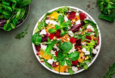 Ensalada vibrante con espinacas, naranja, remolacha y queso feta, que muestra una forma creativa de entender para qué sirve la alcachofa en combinaciones frescas