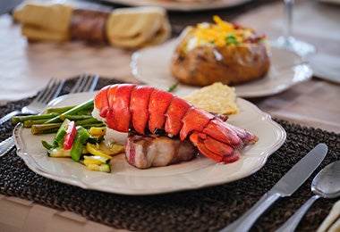 Langosta hervida con papas y verduras, uno de los platos con mariscos más elegantes