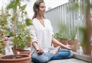 Una mujer haciendo meditación con la postura de la flor de loto 