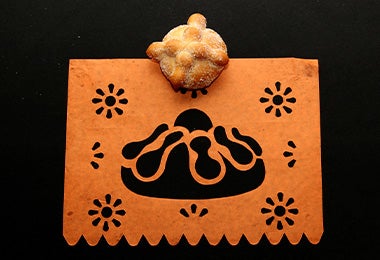 Pan dulce sobre un bordado naranja de pan y figurillas
