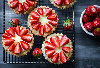 5 platos de gelatina de frutos rojos sin lactosa con fresas encima 