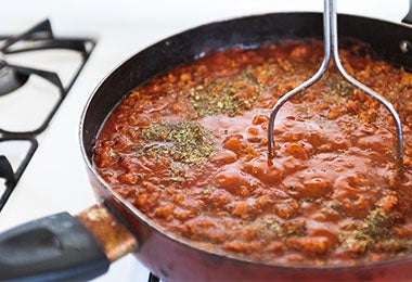 Salsa casera con carne y ají cacho de cabra en sartén sobre estufa