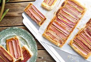 Tarta de ruibarbo con tiras rosadas alineadas, servida en una bandeja
