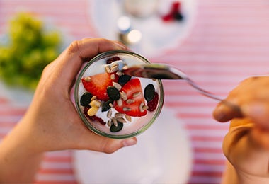 Una persona comiendo un yoghurt griego después de hacer ejercicios para principiantes