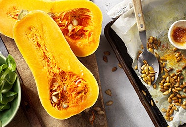 Zapallo tipo Butternut partida por la mitad, con semillas y lista para asar