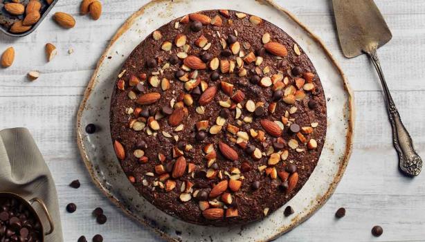 Torta de chocolate decorada con almendras sin pelar enteras y trituradas 