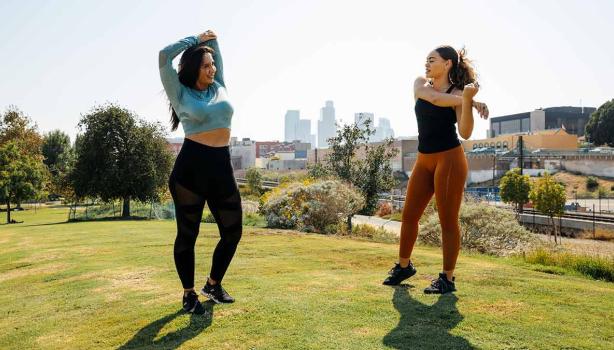 Dos mujeres haciendo estiramientos para empezar con ejercicios para principiantes