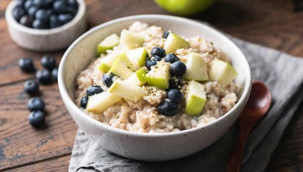 Plato de porridge con arándanos y manzana verde
