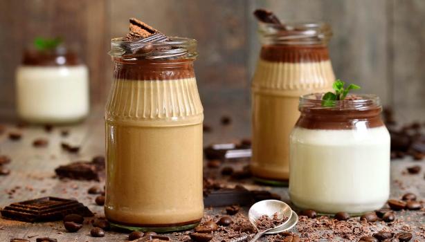 Tres tipos de mousse en vaso con una cuchara y chocolate espolvoreado.