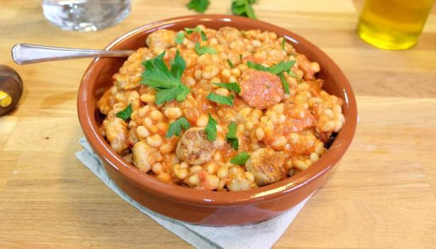 Cassoulet tradicional servido en cazuela de barro con porotos y salchicha