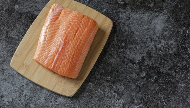 Filete de salmón fresco sobre tabla de madera