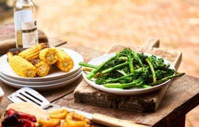 Choclos y espárragos en un asado vegetariano Choclos y espárragos sobre una mesa de madera en un asado vegetariano