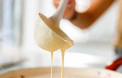 Una mujer preparando panqueques con un cucharón