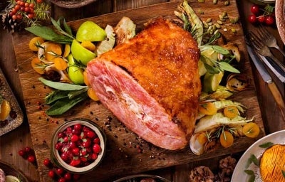 Un jamón de pavo acompañado de diferentes guarniciones navideñas. Un jamón de pavo acompañado de diferentes guarniciones navideñas.