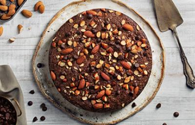Torta de chocolate decorada con almendras sin pelar enteras y trituradas 