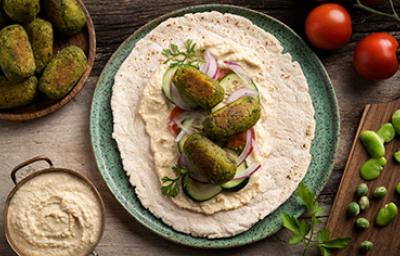 El falafel es una comida libanesa que se consume en todo Medio Oriente Falafel con verduras, tahini y pan pita, una comida libanesa tradicional.