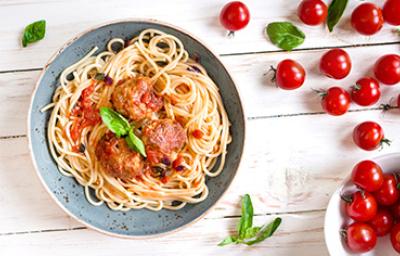 Espagueti con una salsa boloñesa italiana y albóndigas con unas hojitas de albahaca Espagueti con una salsa boloñesa italiana y albóndigas con unas hojitas de albahaca
