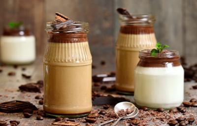 Tres tipos de mousse en vaso con una cuchara y chocolate espolvoreado. Tres tipos de mousse en vaso con una cuchara y chocolate espolvoreado.