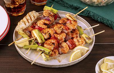 Pinchos con camarones y langostinos al ajillo con verduras y rodajas de limón mandarino Pinchos con camarones y langostinos al ajillo con verduras y rodajas de limón mandarino