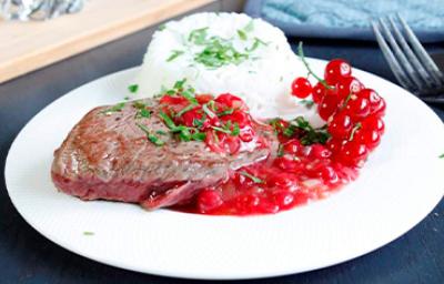 Plato de carne, arroz y salsa de grosellas