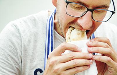 Hombre degustando unas deliciosas empanadas de hojaldre.