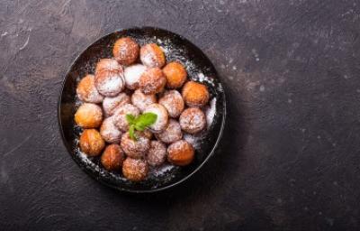 Plato de buñuelos de yuca espolvoreados vistos desde un ángulo cenital.