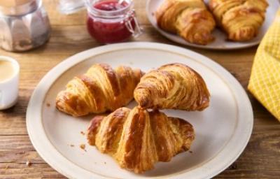 Tres deliciosos croissants de almendras frescos sobre un plato.